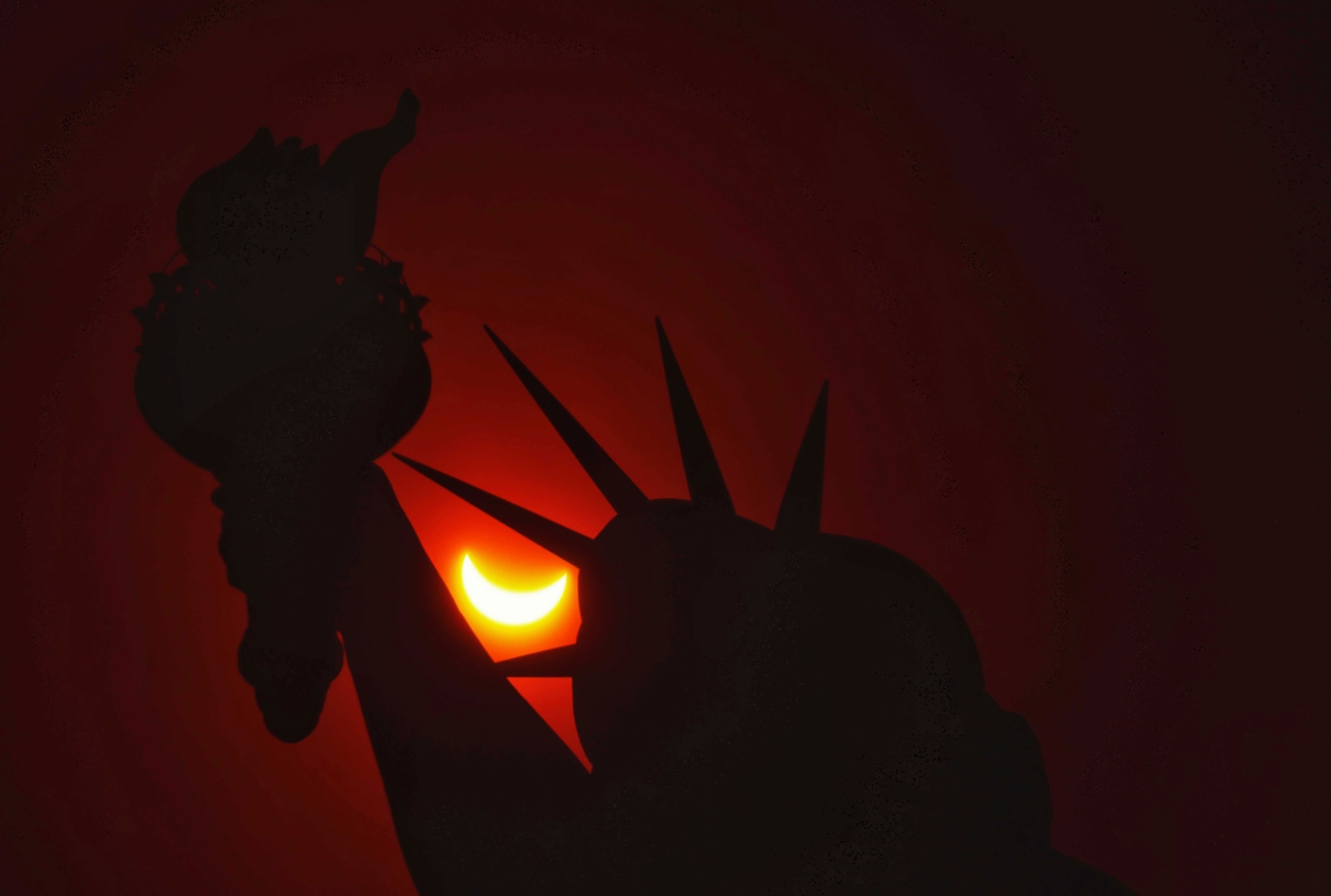 PHOTO: A partial eclipse shines through the Statue of Liberty, New York, April 8, 2024. 