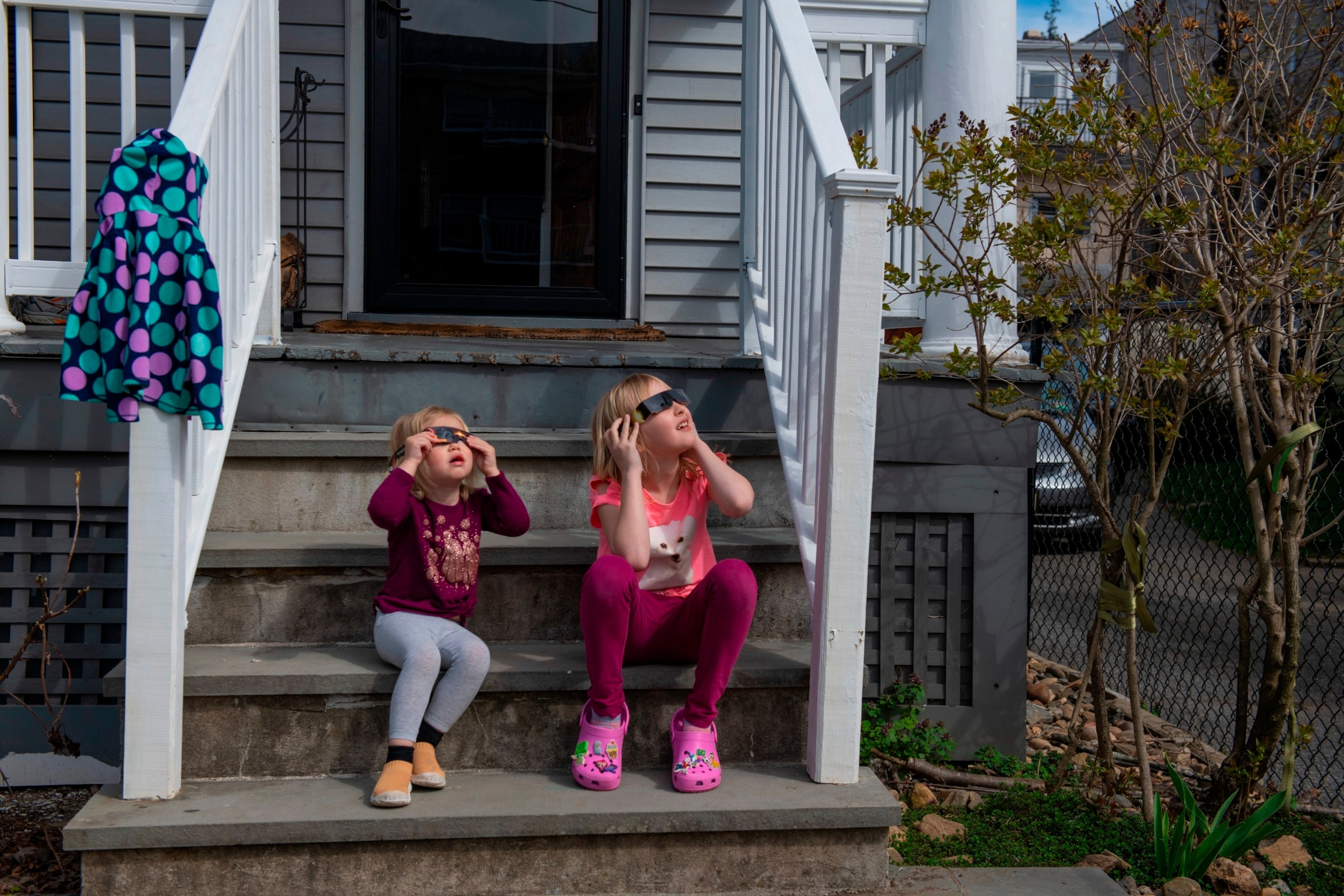 PHOTO: Lily and Clara Nandi watch the eclipse at almost full totality in Hastings on Hudson, NY April 8, 2024.