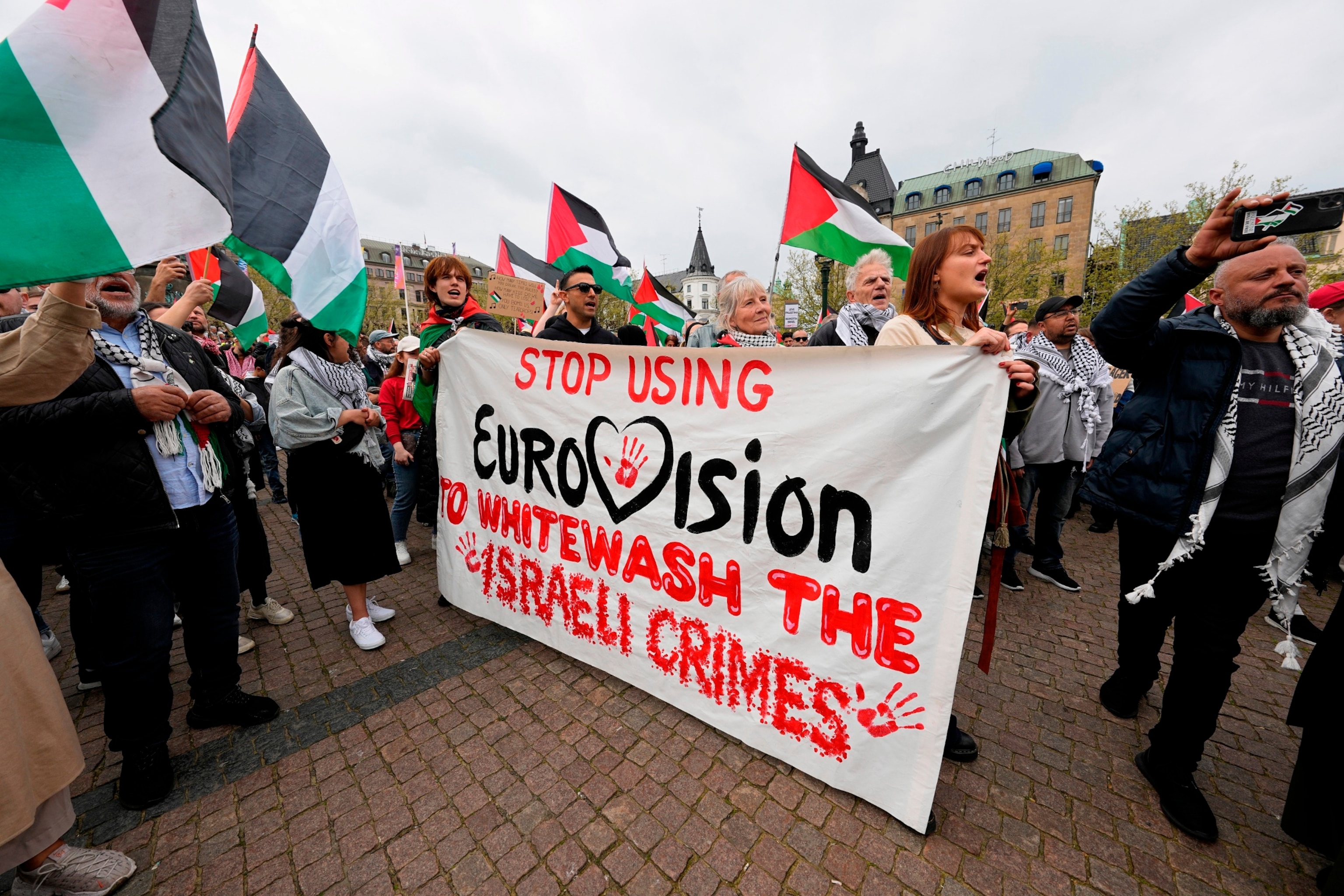 PHOTO: People carry a banner and wave Palestinian flags during a pro-Palestinian demonstration for excluding Israel from Eurovision ahead of the second semifinal at the Eurovision Song Contest in Malmo, Sweden, Thursday, May 9, 2024.