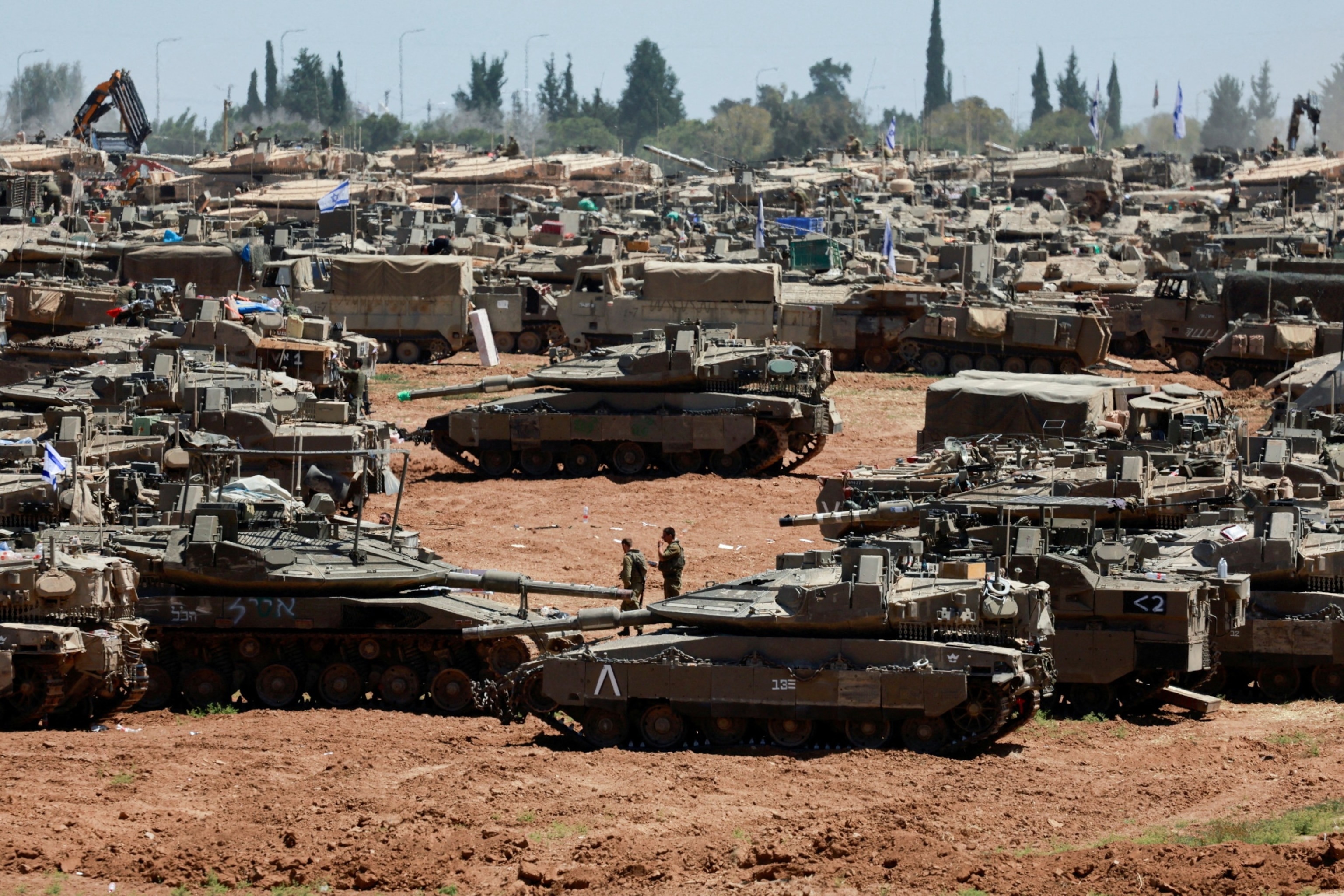 PHOTO: Israeli soldiers walk next to military vehicles near the Israel-Gaza border, amid the ongoing conflict between Israel and the Palestinian Islamist group Hamas, in southern Israel, May 8, 2024.