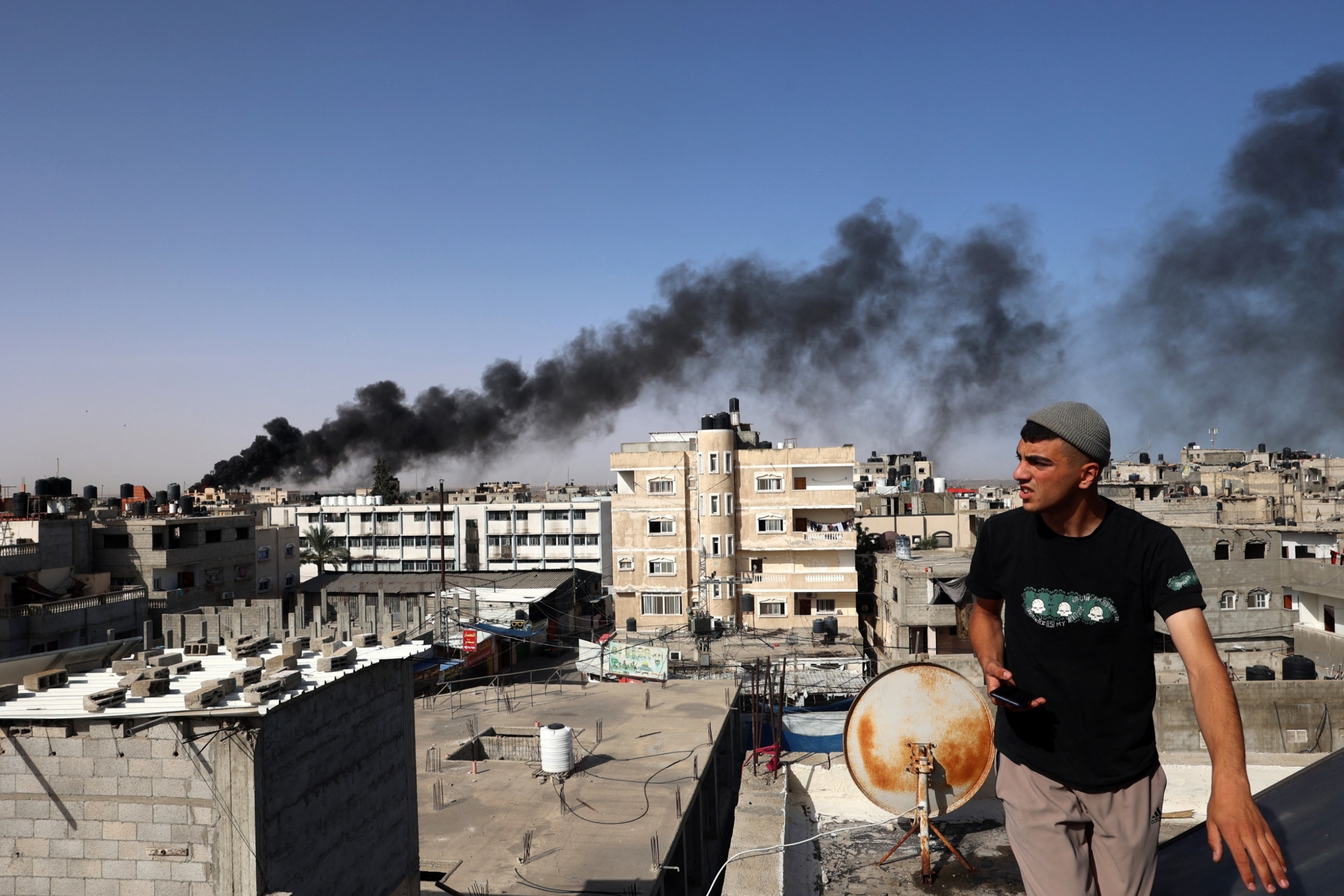 PHOTO: A man looks on as thick, black smoke rises from a fire in a building caused by Israeli bombardment in Rafah in the southern Gaza Strip, May 10, 2024.