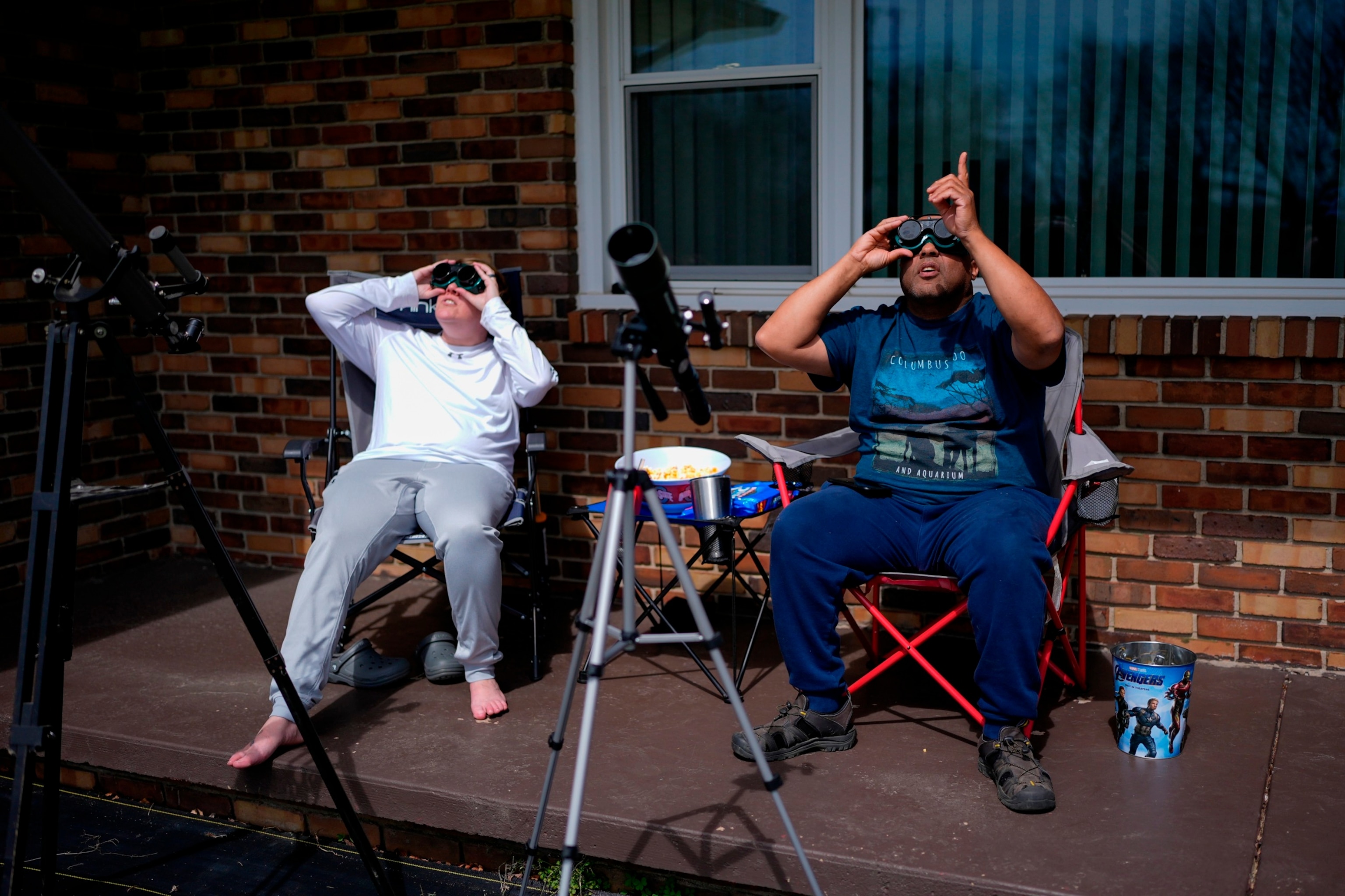 PHOTO: Melissa, left, and Michael Richards watch through solar goggles as the moon partially covers the sun during a total solar eclipse, as seen from Wooster, Ohio, April 8, 2024.